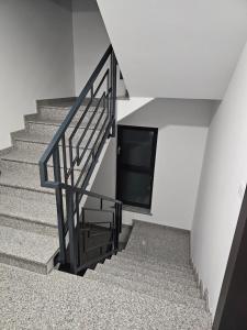a staircase with a black railing and a television at visitor's house 5 in Rădăuţi