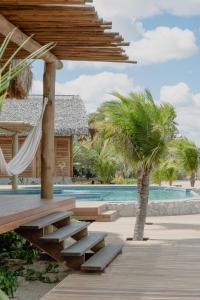 a resort with a hammock and a swimming pool at K08 Bangalôs in Galinhos