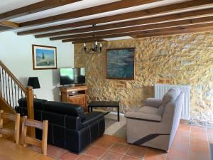 a living room with a couch and a chair at Cottage de La Mothe in Marnac