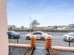 a fence with cars parked in a parking lot at Awel-Y-Mor in Aberaeron +25 photos