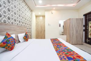 a bedroom with a white bed with colorful pillows at FabHotel Garden Tree in Bhubaneshwar