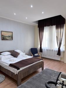 a bedroom with a bed and a chair in it at Baross-hat 5 in Szolnok
