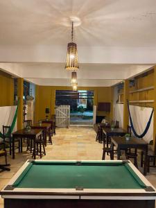 a pool table in a room with tables and chairs at Praia Jeri House in Jericoacoara