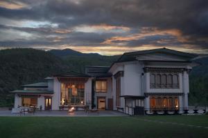 a large building with a sunset in the background at The Postcard Dewa, Thimphu, Bhutan in Thimphu