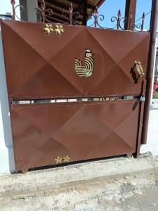 a brown metal door with a rooster on it at Rooster Retreat in Aridaia