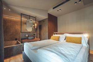 ein Schlafzimmer mit einem großen Bett und einer Badewanne in der Unterkunft Boutique Hotel Villa Alberta in Nago-Torbole