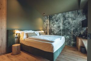 ein Schlafzimmer mit einem Bett und einem Gemälde an der Wand in der Unterkunft Boutique Hotel Villa Alberta in Nago-Torbole