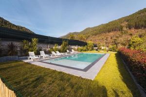 a swimming pool in the yard of a house at Gerês Home Nature in Geres