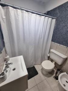 a bathroom with a white shower curtain and a toilet at La Pausa in Santa Rosa +24 photos