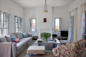 a living room with a couch and a table at Villa Litharia, enchanting location and view in Ioulis