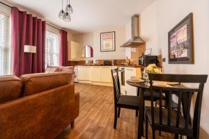 a living room with a couch and a table at Pump House Apartments in Derry Londonderry +78 photos