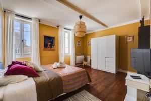 a bedroom with a bed and a flat screen tv at L'Estanquet - Maison d'Hôtes in Gardouch