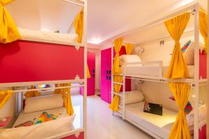 a room with three bunk beds with yellow curtains at goSTOPS Plus Katra in Katra
