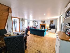 a living room with a blue couch and a tv at Cute Quirky Cottage in Llandow