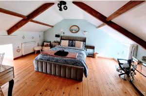a bedroom with a large bed in a room with wooden floors at Cute Quirky Cottage in Llandow +48 photos