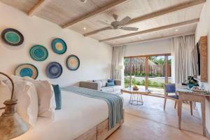 a bedroom with a bed and a living room at Mystique Holbox by Royalton, A Tribute Portfolio Resort in Holbox Island