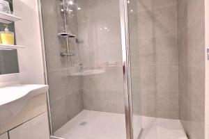 a shower with a glass door in a bathroom at Le Moulin du Bignon in Lassy