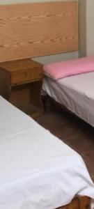 a bedroom with two beds and a wooden headboard at Private apartment beach resort in Hurghada