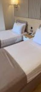 two white beds in a hotel room with at Private apartment beach resort in Hurghada