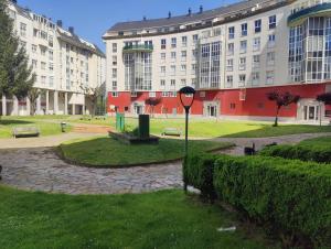 a large building with a park in front of it at Ático espacioso en zona céntrica in Sarria