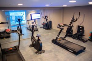 a gym with several exercise bikes and a tv at Acqua Suítes Maceió in Maceió