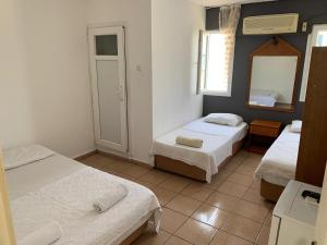 a room with two beds and a mirror at denge pansiyon in Datca