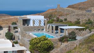 a villa with a swimming pool on a hill at Villa Litharia, enchanting location and view in Ioulis