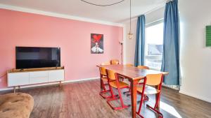 a dining room with a table and a tv at Spacious Flat 2nd Floor near station in Karlsruhe
