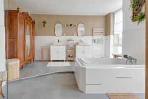 a bathroom with a large white tub and a sink at Secret de Briques - classé 4 étoiles in Vigneux-Hocquet +19 photos