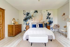 a bedroom with a large bed and a dresser at Secret de Briques - classé 4 étoiles in Vigneux-Hocquet