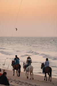a group of people riding horses on the beach at Villa Conduru III Kite House Preá 100m from Beach in Cruz