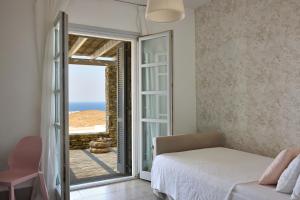 a bedroom with a bed and a view of the ocean at Villa Litharia, enchanting location and view in Ioulis +61 photos