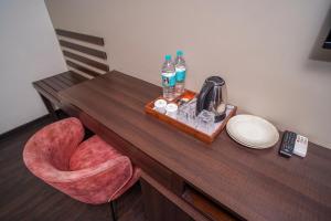 a table with a chair and a tray with water bottles at Open Hotel by Olive - Slate in Chennai +76 photos