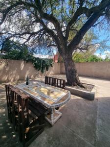 a table and two benches next to a tree at La Pausa in Santa Rosa
