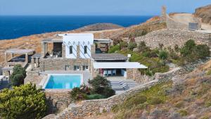 a house on a hill with a swimming pool at Villa Litharia, enchanting location and view in Ioulis