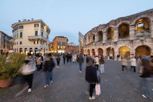 a group of people walking around a city street at Dimora Oberdan 1800 - Duplex 70m from Arena 6 Beds in Verona