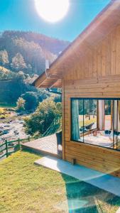 a wooden house with a view of the mountains at Refúgio do Vale Estalagem in Annitapolis