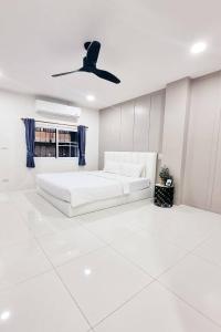 a white bedroom with a bed and a ceiling fan at Dad N Mom's House By Thongnak Apartment in Pattaya