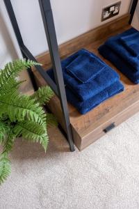 a mirror with blue towels on a wooden shelf at Pump House Apartments in Derry Londonderry