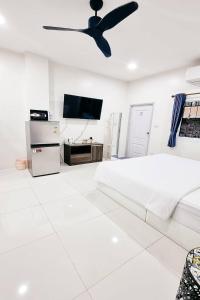 a white bedroom with a bed and a ceiling fan at Dad N Mom's House By Thongnak Apartment in Pattaya