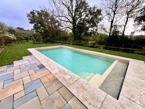 a swimming pool in a yard with a patio at Lower Marsh Farm Glamping in Saltash