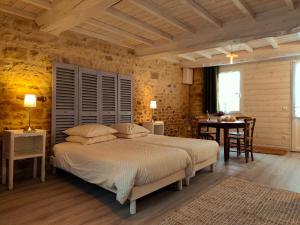 a bedroom with a bed and a table and a dining room at Omaha Secret Normandy Cottages in Saint-Laurent-sur-Mer