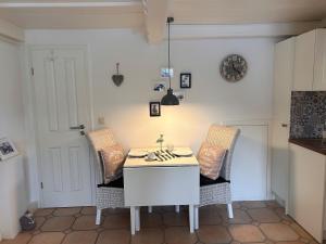 a kitchen with a white table and two chairs at Lykke in Wrixum