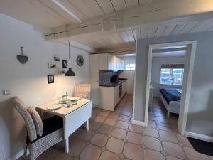 a living room with a table and a kitchen at Lykke in Wrixum