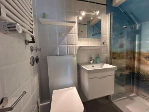 a small bathroom with a toilet and a sink at Lykke in Wrixum +5 photos