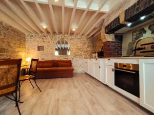 a kitchen with a couch and a table in a room at Omaha Secret Normandy Cottages in Saint-Laurent-sur-Mer +35 photos