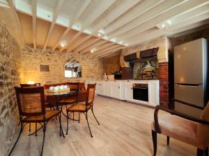 a kitchen and dining room with a table and chairs at Omaha Secret Normandy Cottages in Saint-Laurent-sur-Mer