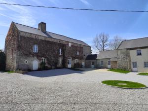 a large brick building with a driveway in front of it at Omaha Secret Normandy Cottages in Saint-Laurent-sur-Mer
