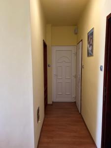 a hallway with yellow walls and a white door at Szekcsői Kuckó in Kaposszekcső