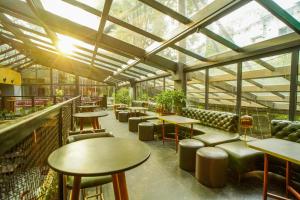 a restaurant with tables and chairs and windows at Open Hotel by Olive - Slate in Chennai